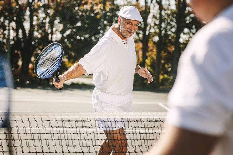 Persona anziana che gioca a tennis. Quali altre attività si possono fare dopo i 70 anni?